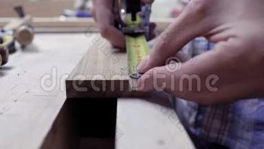 用金属胶带测量板的长度。 工人用木板在木板上做测量